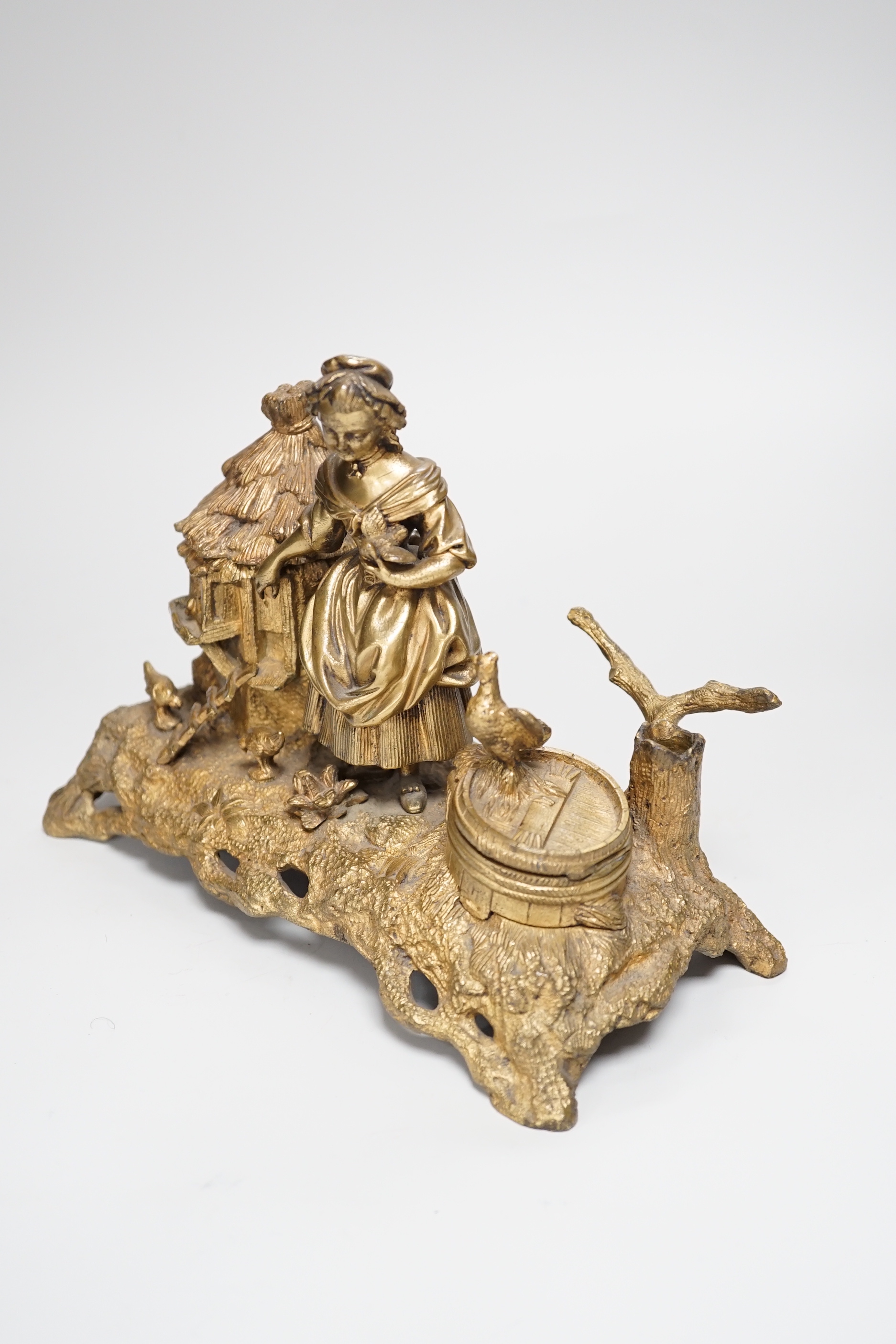 A 19th century gilt bronze inkwell decorated with a farmyard scene and country maiden, 18cm high